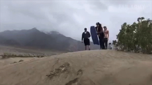 A Group Of People Walking On Top Of A Sand Dune With Mountains In The Background And Failarmy Written On The Bottom GIF