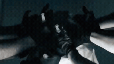 A Group Of People Wearing Black Gloves Are Putting Their Hands Together In A Huddle . GIF