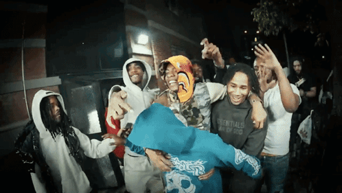 A Group Of People Wearing Essentials Sweatshirts Are Dancing GIF