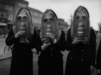 A Group Of People Wearing Gas Masks Are Standing In A Line GIF