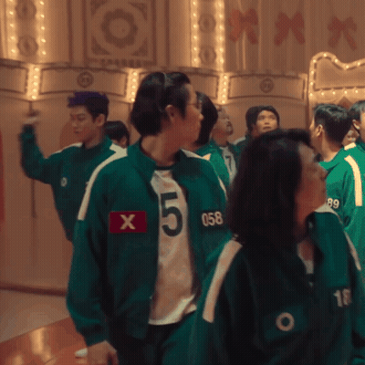 A Group Of People Wearing Green Jackets With The Number 5 On The Front GIF