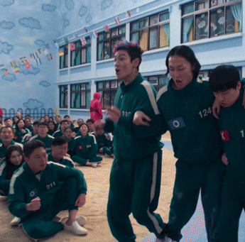 A Group Of People Wearing Green Jumpsuits With The Number 211 On Them GIF