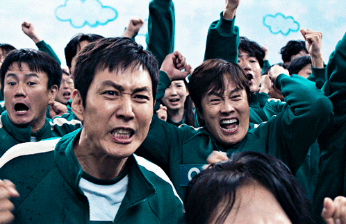 A Group Of People Wearing Green Sweatshirts With The Letter C On The Front GIF