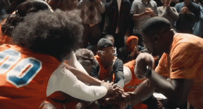 A Group Of People Wearing Orange Jerseys With The Number 80 On Them GIF