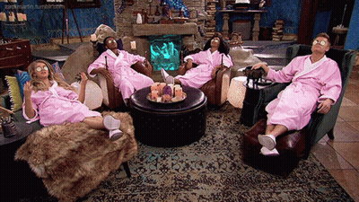 A Group Of People Wearing Pink Bathrobes Are Sitting In A Living Room GIF