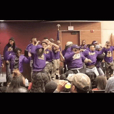 A Group Of People Wearing Purple Shirts With The Word Squad On Them Are Dancing In A Room GIF