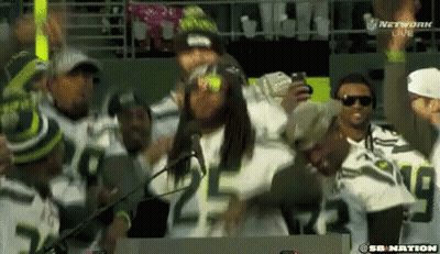 A Group Of People Wearing Seahawks Jerseys Are Dancing In The Stands GIF