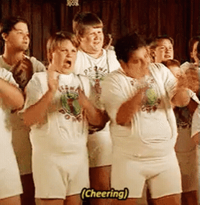 A Group Of People Wearing White Shirts And Shorts Are Standing In A Line And Cheering . GIF