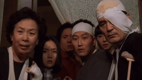 A Group Of People With Bandages On Their Heads Are Looking At Something GIF