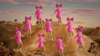 A Group Of Pink Dolls With Bows On Their Heads Are Dancing On A Hill GIF
