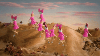 A Group Of Pink Dolls With Bows On Their Heads Are Dancing On Top Of A Hill GIF