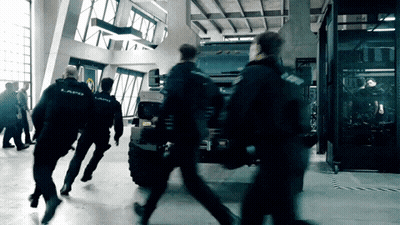 A Group Of Police Officers Are Running Towards A Vehicle That Says ' Lapd ' On It GIF
