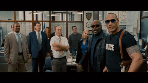 A Group Of Police Officers Are Standing In A Office GIF