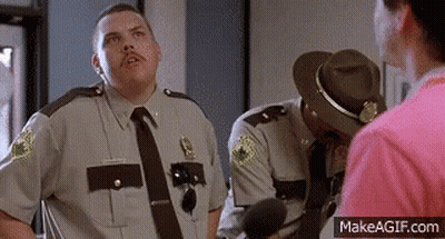 A Group Of Police Officers Are Standing Next To Each Other And Talking To Each Other . GIF