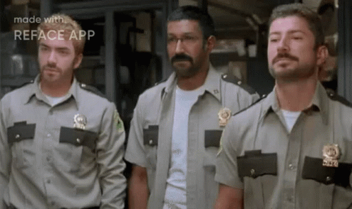 A Group Of Police Officers Are Standing Next To Each Other In A Line . GIF