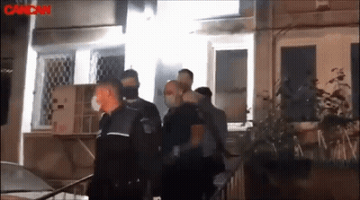 A Group Of Police Officers Are Standing Outside Of A Building With The Word Cancan In The Corner GIF