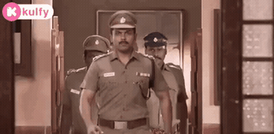A Group Of Police Officers Walking Down A Hallway . GIF