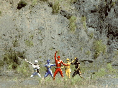 A Group Of Power Rangers Are Standing In A Field With A Mountain In The Background GIF