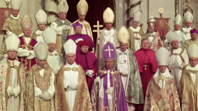 A Group Of Priests Are Posing For A Picture With A Cross On Their Hats GIF