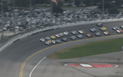 A Group Of Race Cars Are Lined Up On A Race Track GIF