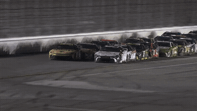 A Group Of Race Cars Are Lined Up On A Race Track GIF