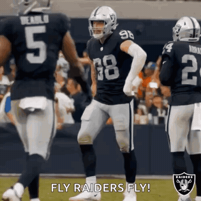 A Group Of Raiders Football Players Are Standing On A Field During A Game . GIF