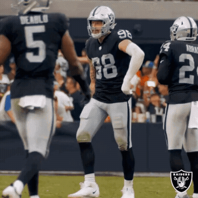 A Group Of Raiders Football Players Are Standing On A Field GIF