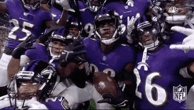 A Group Of Ravens Football Players Are Posing For A Picture Together . GIF