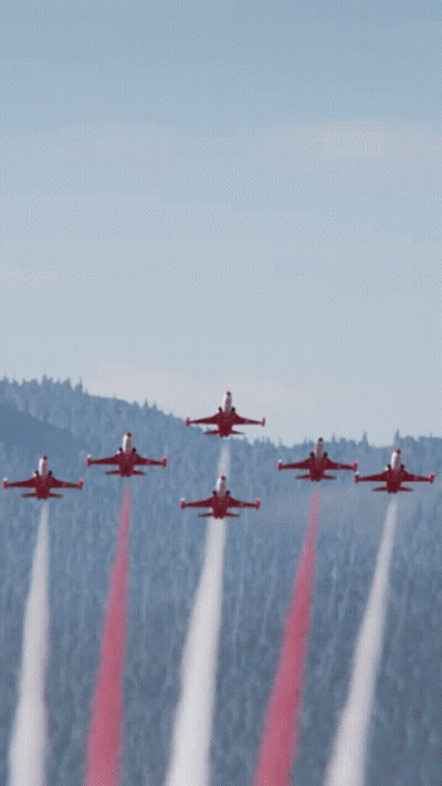 A Group Of Red Jets Flying In Formation With Smoke Trails GIF