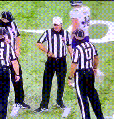 A Group Of Referees Standing On A Field With One Wearing A Jersey That Says ' U ' On It GIF