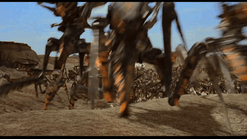 A Group Of Robots Are Walking Across A Desert GIF