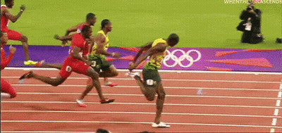 A Group Of Runners Are Running On A Track With The Olympic Rings In The Background . GIF
