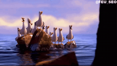 A Group Of Seagulls Standing On Rocks In The Ocean GIF