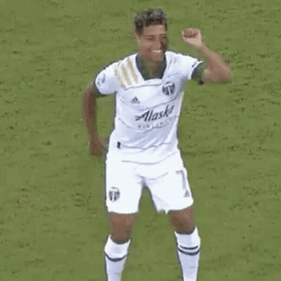 A Group Of Soccer Players Are Celebrating A Goal On A Soccer Field . GIF
