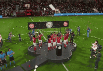 A Group Of Soccer Players Are Celebrating On A Stage With A Trophy GIF