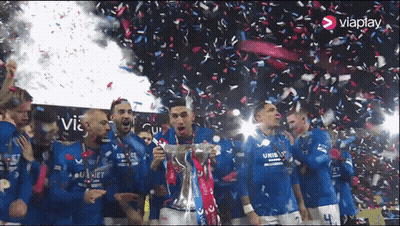 A Group Of Soccer Players Are Celebrating With A Trophy And Confetti With The Word Viaplay In The Corner GIF