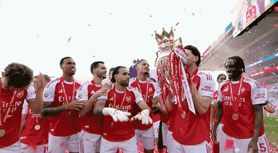 A Group Of Soccer Players Are Celebrating With A Trophy On A Field . GIF