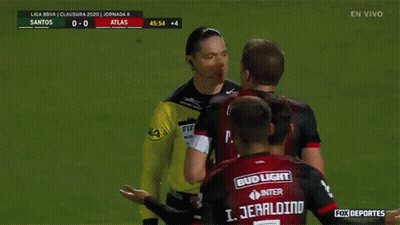 A Group Of Soccer Players Are Gathered Around A Referee Wearing A Bud Light Jersey GIF