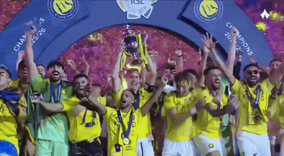 A Group Of Soccer Players Are Holding Up A Trophy Under A Sign That Says Champions GIF