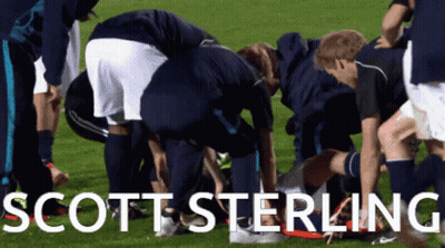 A Group Of Soccer Players Are Huddled Around Scott Sterling On The Field GIF