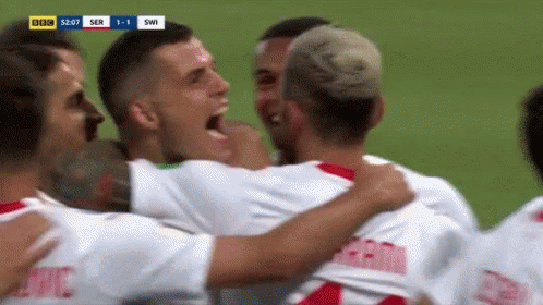 A Group Of Soccer Players Are Hugging Each Other And Celebrating A Goal . GIF