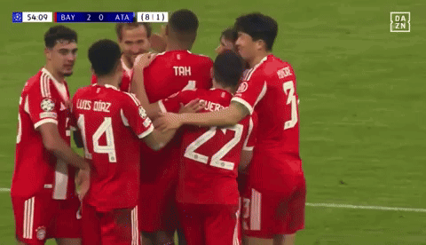 A Group Of Soccer Players Are Hugging Each Other On A Field . One Of The Players Has The Number 14 On His Jersey . GIF
