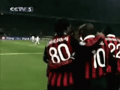 A Group Of Soccer Players Are Hugging Each Other On A Soccer Field . GIF