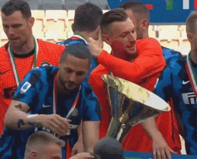 A Group Of Soccer Players Are Hugging Each Other While Holding A Trophy . GIF