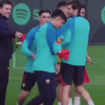 A Group Of Soccer Players Are Hugging On A Field . GIF