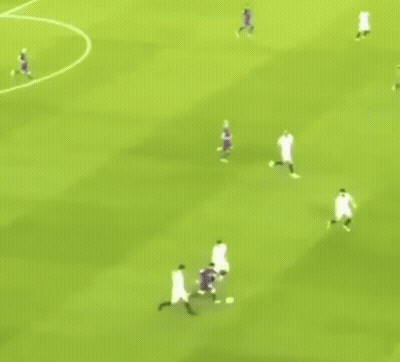 A Group Of Soccer Players Are Playing A Game On A Field . GIF