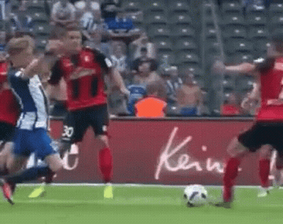 A Group Of Soccer Players Are Playing A Game On A Field With A Sign That Says Kein In The Background . GIF