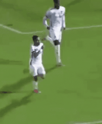 A Group Of Soccer Players Are Playing A Game On A Green Field . GIF