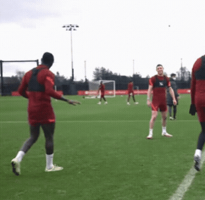 A Group Of Soccer Players Are Playing On A Field And One Of Them Is Wearing A Jersey That Says ' Liverpool ' GIF
