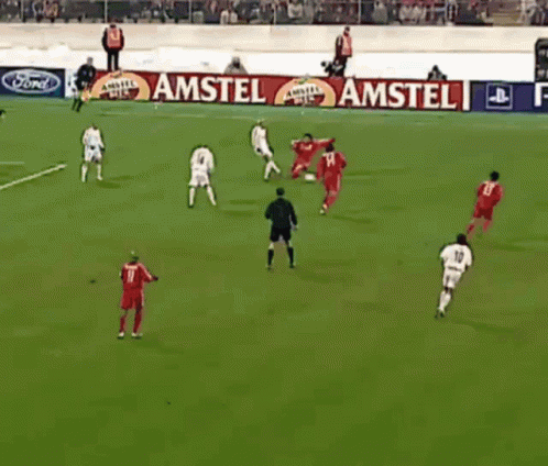 A Group Of Soccer Players Are Playing On A Field With A Playstation 2 Banner Behind Them GIF